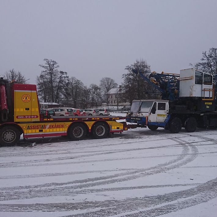 Bärgare transporterar fordon i vinterväglag