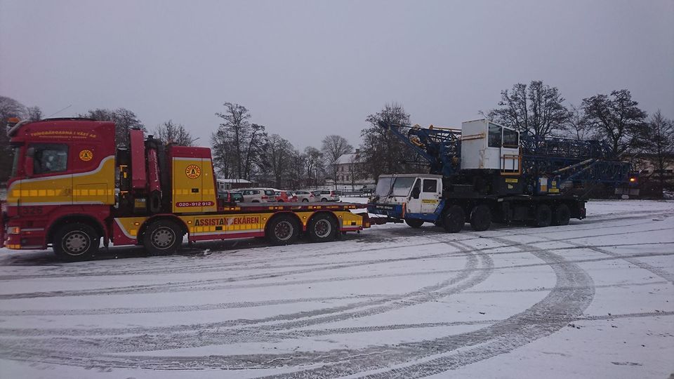 Bärgare transporterar fordon i vinterväglag